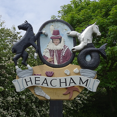 The Heacham village sign, showing Pocahontas with a horse and a crab-clawed sea-horse as supporters.